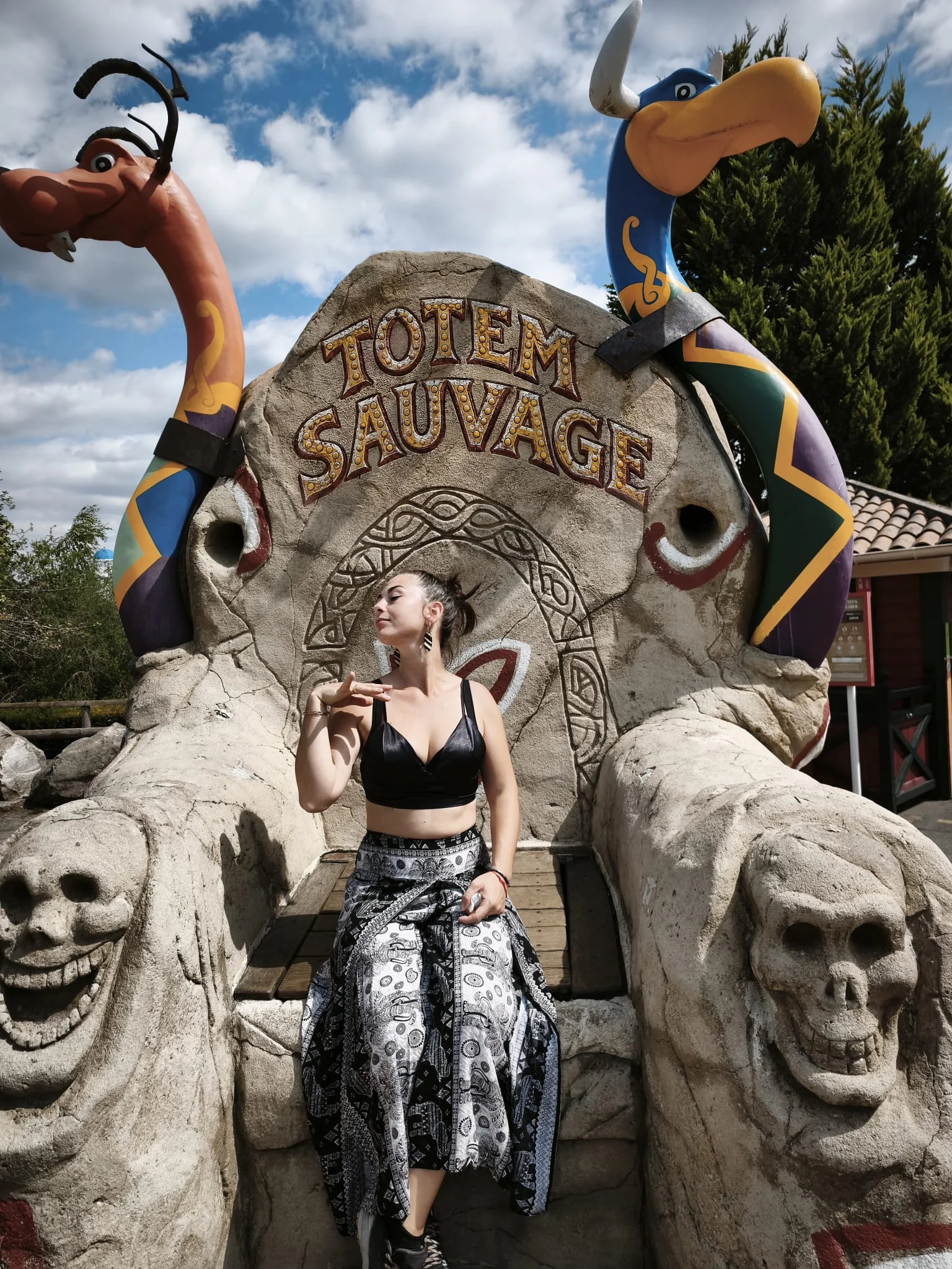 Camille Marchand, artiste de Totem Sauvage, assise sur un trône sculpté gravé TOTEM SAUVAGE